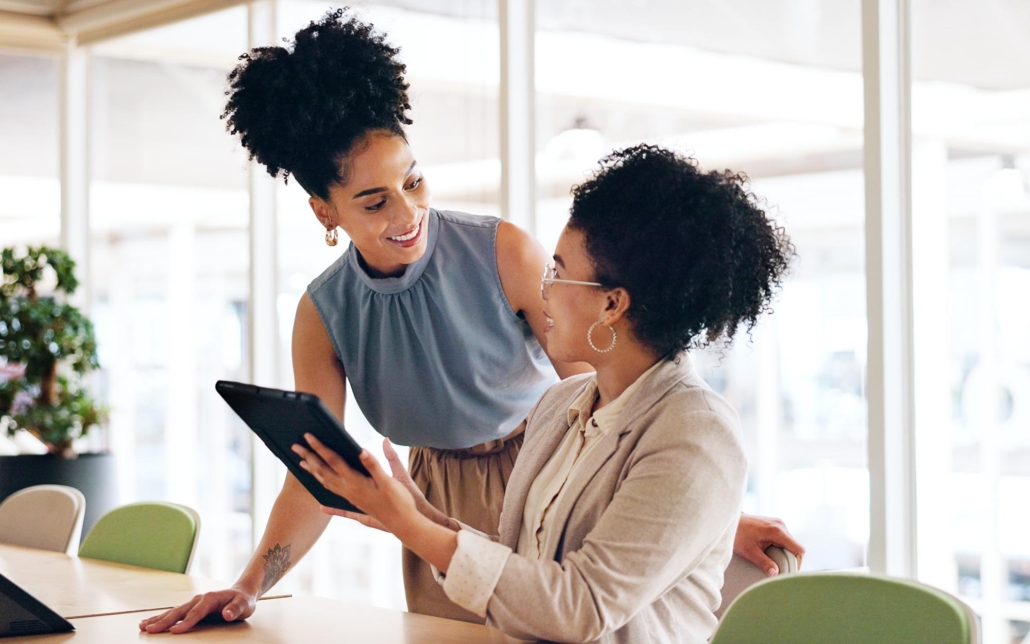 Two office workers talking with an ipad