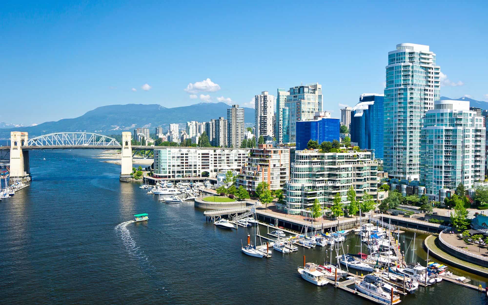 The Vancouver skyline features a breathtaking view of the city’s iconic high-rises and natural backdrop. Towering buildings are set against a backdrop of mountains and waterfront, capturing the vibrant and scenic essence of this dynamic urban landscape.
