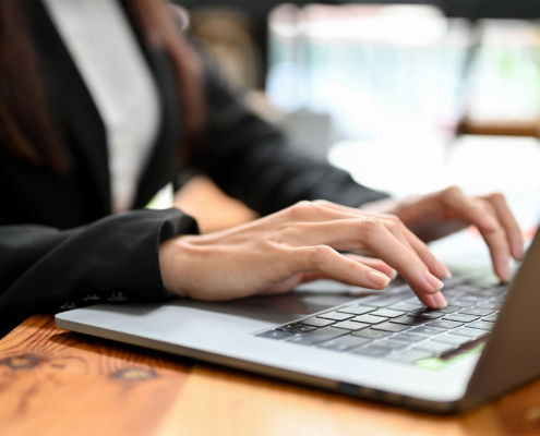 Close-up image, Female office worker working on laptop computer, typing on keyboard