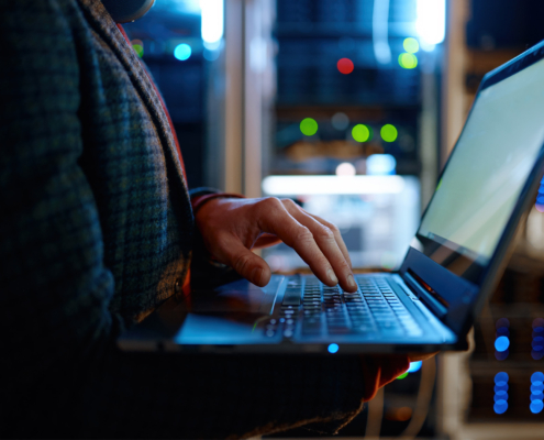 IT technician checking the servers vitals using laptop computer